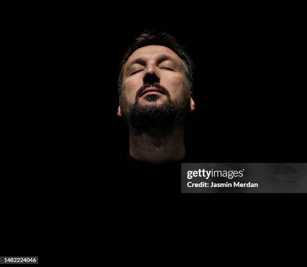 man posing in sunlight shadow - meditation concentration stock pictures, royalty-free photos & images