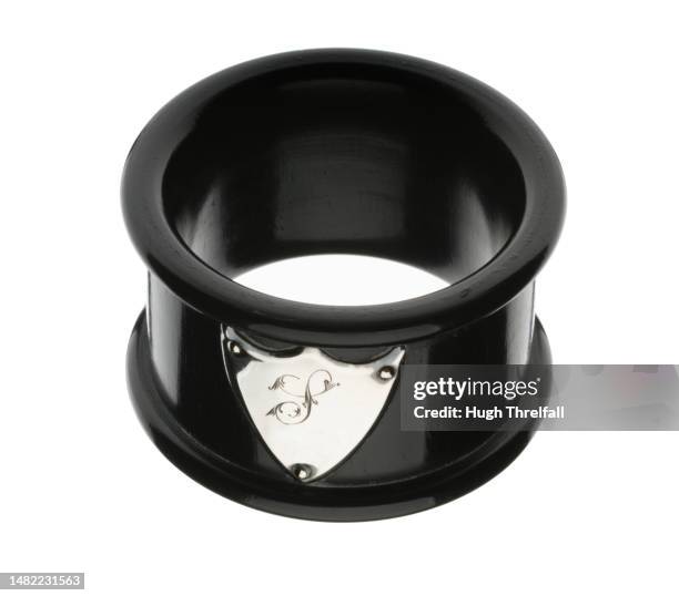 a napkin ring made from ebony wood. a silver shield with the letter s denotes its owner. - serviettenring stock-fotos und bilder