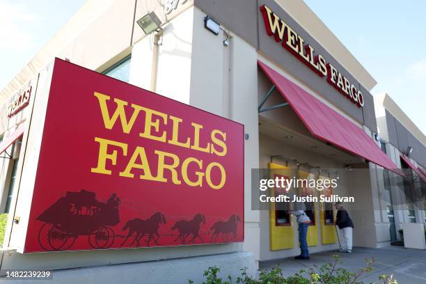 Customers use ATMs at a Wells Fargo Bank on April 14, 2023 in San Bruno, California. Wells Fargo reported better-than-expected first quarter earnings...