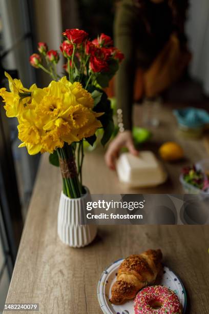 woman packing a bag of lunch to go while her teenage son in making fresh lemonade - daffodil isolated stock pictures, royalty-free photos & images