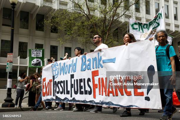 Climate activists march around the World Bank and International Monetary Fund headquarters on April 14, 2023 in Washington, DC. Protesters with...