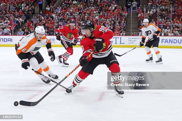 Tyler Johnson of the Chicago Blackhawks controls the puck under pressure from Travis Sanheim of the Philadelphia Flyers during a game at the United...