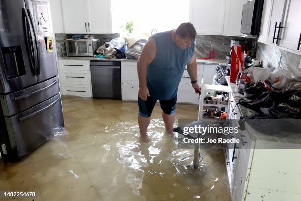 John Forman sees what he can salvage from his kitchen after flood waters inundated the home he has lived in for nine years on April 14, 2023 in Fort...