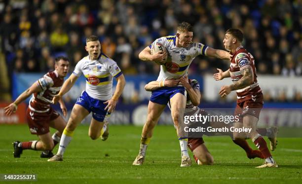 Matt Nicholson of Warrington is tackled by Sam Powell of Wigan during the Betfred Super League between Warrington Wolves and Wigan Warriors at The...