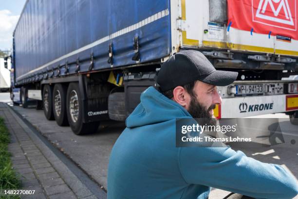 A striking truck driver next to trucks at a rest area on the A5 highway on April 14, 2023 near Darmstadt, Germany. The approximately 60 truck...