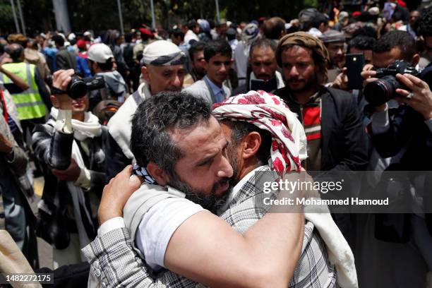 Yemeni embraces a relative freed through a prisoner exchange between warring sides at the Sana'a International Airport on April 14, 2023 in Sana'a,...