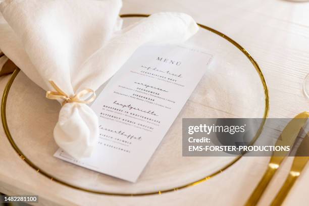 elegant wedding occasion dining place setting with menu and napkin on glass plate. - wedding table setting stock pictures, royalty-free photos & images