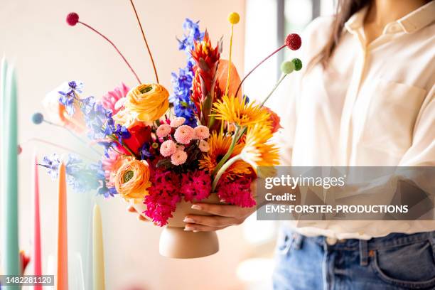 event planner decorating the venue with colourful flowers in a vase. - floral arranging stock pictures, royalty-free photos & images