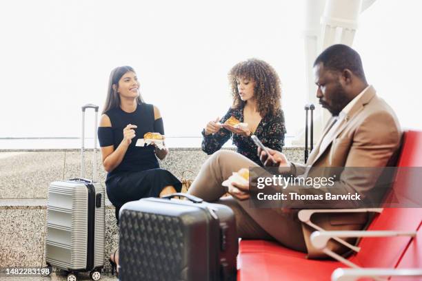 medium shot of friends waiting for flight in departure area of airport - maroc business stock-fotos und bilder