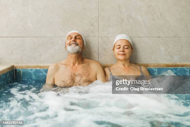 senior couple in love relaxing in hot tub. wellness in health resort - paar pool zufriedenheit stock-fotos und bilder