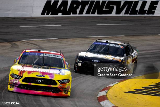 Gray Gaulding, driver of the Panini NFT Ford, and Kyle Sieg, driver of the Night Owl Ford, drive during practice for the NASCAR Xfinity...