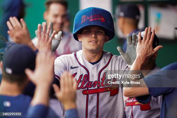 Austin Riley of the Atlanta Braves celebrates with teammates in the dugout after hitting a two-run home run to left field against Kansas City Royals...