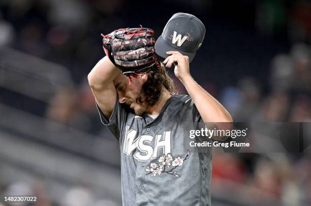 Hunter Harvey of the Washington Nationals wipes his forehead as he walks to the dugout after being taking out of the game in the seventh inning...