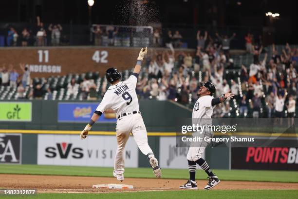 Nick Maton of the Detroit Tigers celebrates his game winning 11th inning walk off three run home run with first base coach Alfredo Amezaga to beat...