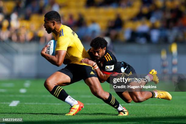 Salesi Rayasi of the Hurricanes is tackled by Emoni Narawa of the Chiefs during the round eight Super Rugby Pacific match between Hurricanes and...