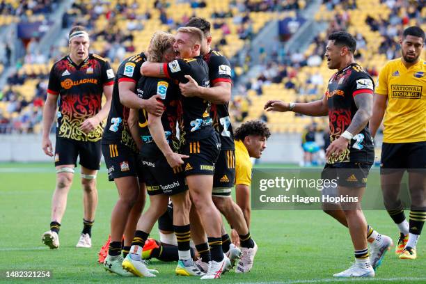Damian McKenzie of the Chiefs celebrates with teammates after scoring a try during the round eight Super Rugby Pacific match between Hurricanes and...