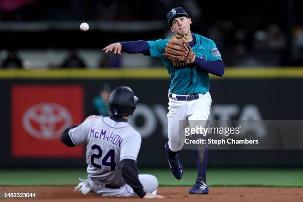 Sam Haggerty of the Seattle Mariners turns a double play past Ryan McMahon of the Colorado Rockies during the eighth inning at T-Mobile Park on April...