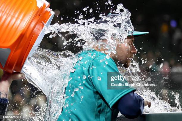 Tom Murphy douses Jarred Kelenic of the Seattle Mariners with water after the game against the Colorado Rockies at T-Mobile Park on April 14, 2023 in...