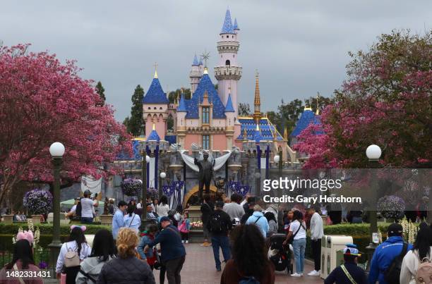 People walk along Main Street in front of the Sleeping Beauty Castle at the Disneyland theme park on April 13 in Anaheim, California.