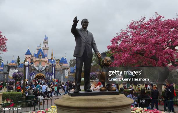 Statue of Walt Disney and Mickey Mouse stands on Main Street in front of the Sleeping Beauty Castle at the Disneyland theme park on April 13 in...