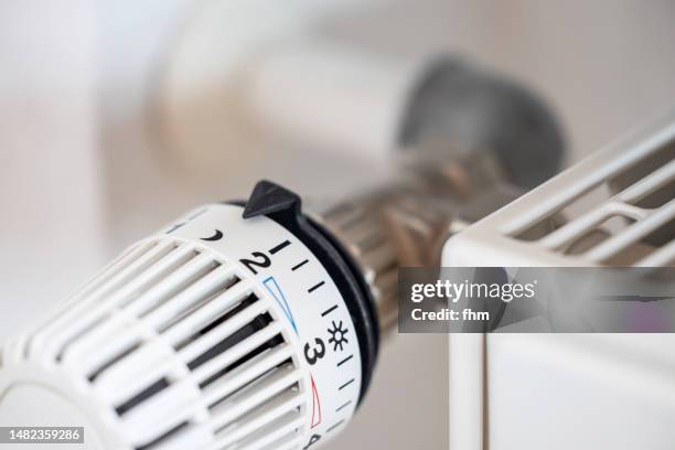 thermostat on a heater at night-level - heizung stock-fotos und bilder
