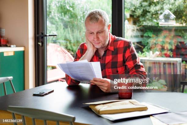 worried man checking bills at home - statement stock pictures, royalty-free photos & images