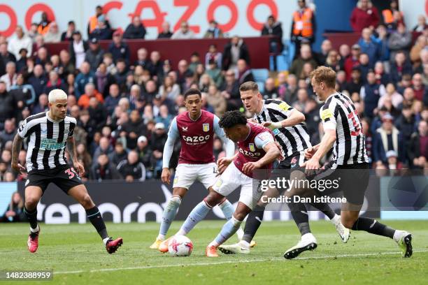 Ollie Watkins of Aston Villa scores the team's second goal whilst under pressure from Sven Botman and Dan Burn of Newcastle United during the Premier...