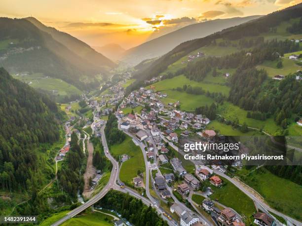 aerial drone sunset scene of val gardena city is a valley in northern italy, in the dolomites of south tyrol. it is best known as a tourist skiing, rock climbing, and woodcarving area - emerald city stock pictures, royalty-free photos & images