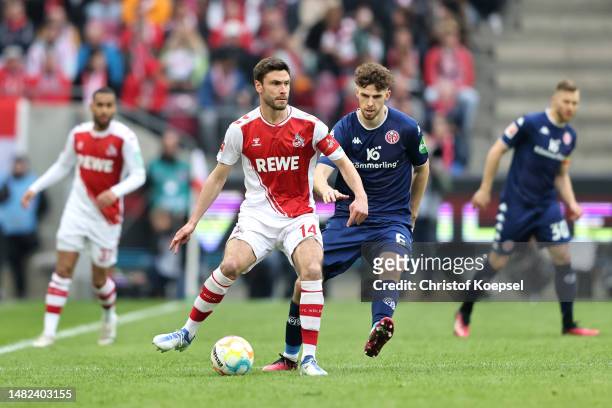 Jonas Hector of 1.FC Koeln passes the ball whilst under pressure from Anton Stach of 1.FSV Mainz 05 during the Bundesliga match between 1. FC Köln...