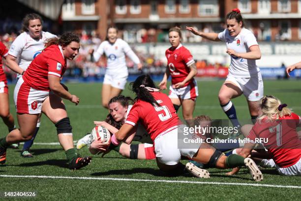 Lucy Packer of England touches down to score the teams first try whilst tackled by Georgia Evans of Wales during the TikTok Women's Six Nations match...