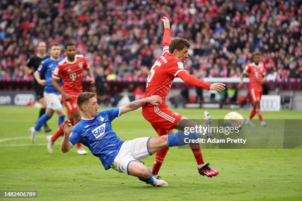 Thomas Mueller of FC Bayern Munich is challenged by Angelo Stiller of TSG Hoffenheim during the Bundesliga match between FC Bayern München and TSG...