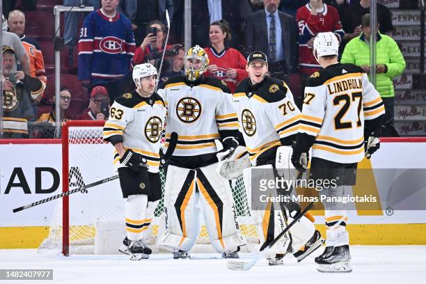 Brad Marchand, goaltenders Jeremy Swayman and Brandon Bussi of the Boston Bruins celebrate a victory against the Montreal Canadiens at Centre Bell on...
