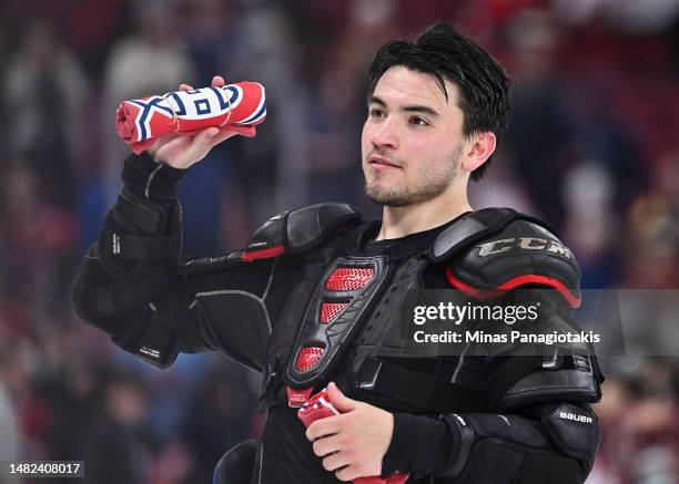 Nick Suzuki of the Montreal Canadiens looks to throw folded t-shirts towards spectators at the conclusion of the 2022-2023 NHL regular season against...