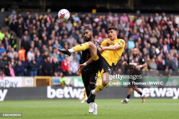 Matheus Nunes of Wolverhampton Wanderers attempts to controls the ball from Rico Henry of Brentford during the Premier League match between...