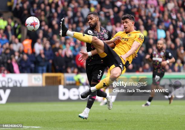 Matheus Nunes of Wolverhampton Wanderers attempts to controls the ball from Rico Henry of Brentford during the Premier League match between...