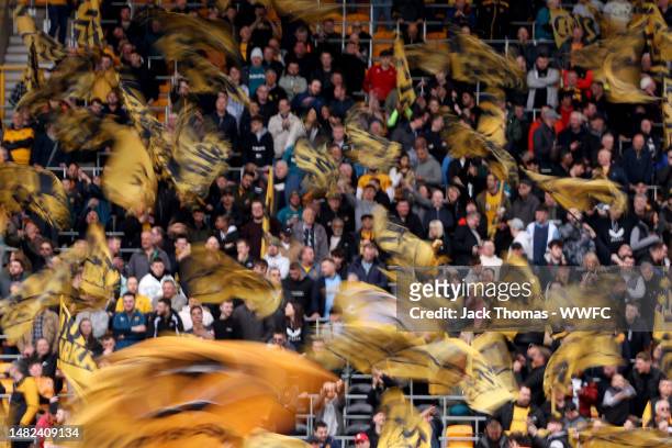 Wolverhampton Wanderers fans wave flags during the Premier League match between Wolverhampton Wanderers and Brentford FC at Molineux on April 15,...