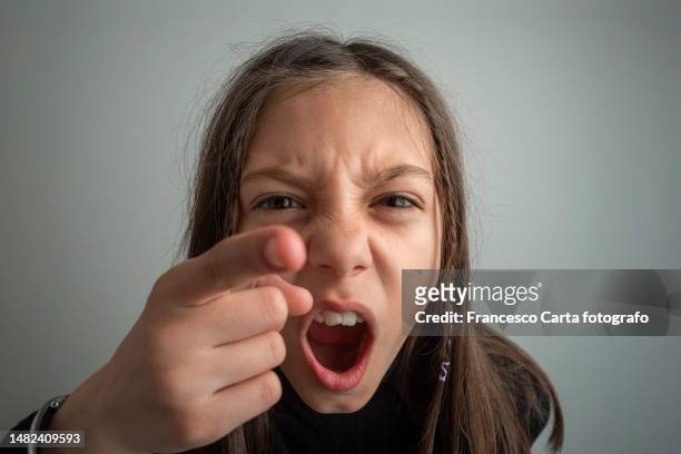 frowning girl point finger to camera - girl pointing bildbanksfoton och bilder