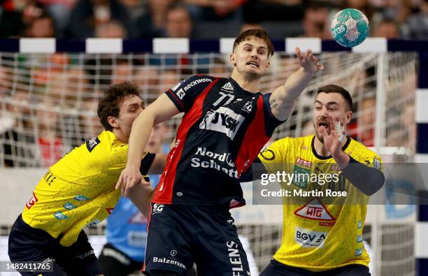 Magnus Röd of SG Flensburg-Handewitt challenge Niclas Kirkelokke and Jannik Kohlbacher of Rhein Neckar Löwen during the DHB Cup semifinal match...