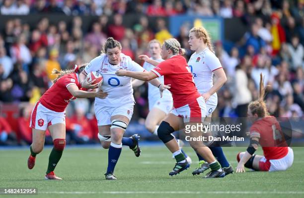 Sarah Beckett of England is tackled by Hannah Jones and Kelsey Jones of Wales during the TikTok Women's Six Nations match between Wales and England...