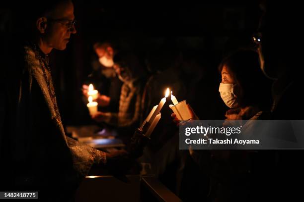 Archpriest Paul Koroluk lights candles during Holy Pascha service at Saint Alban's Anglican - Episcopal Church on April 15, 2023 in Tokyo, Japan. The...