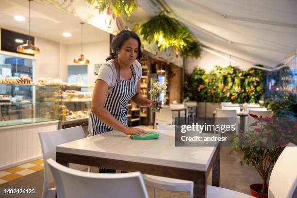 waitress cleaning tables while working at a cafe - empregado do refeitório imagens e fotografias de stock