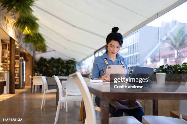 business manager doing the accountancy at a coffee shop - restaurant owner stock pictures, royalty-free photos & images