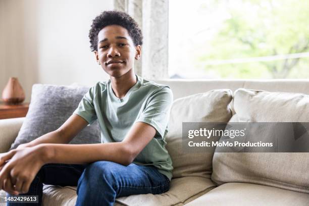 portrait of teenage boy on couch at home - chico adolescente fotografías e imágenes de stock