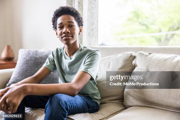 portrait of teenage boy on couch at home - teenage boys stock pictures, royalty-free photos & images