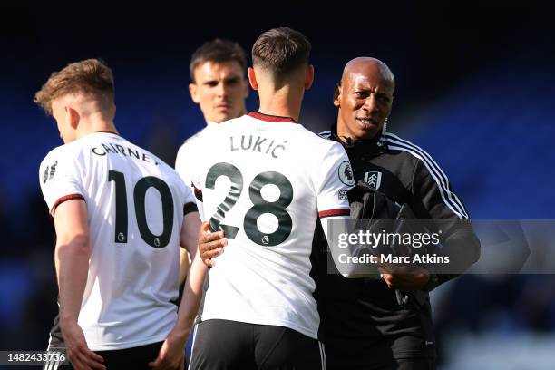 Luis Boa Morte, Assistant Manager of Fulham embraces Sasa Lukic after the team's victory in the Premier League match between Everton FC and Fulham FC...
