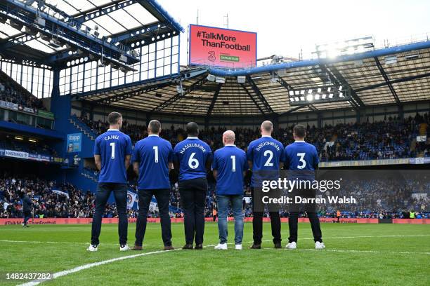 Chelsea Legends, Gary Cahill, Eidur Gudjohnsen and Jimmy Floyd Hasselbaink stand with fans to promote the Samaritans helpline number on the back of...