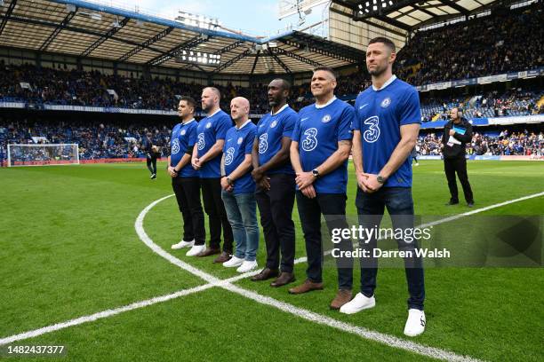 Chelsea Legends, Gary Cahill, Eidur Gudjohnsen and Jimmy Floyd Hasselbaink stand with fans to promote the Samaritans helpline number on the back of...