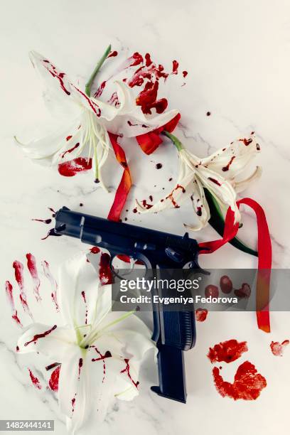 black gun on the table covered in blood - lily bouquet stock pictures, royalty-free photos & images