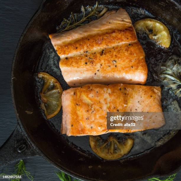 samonfilets in eisenpfanne - salmon steak stock-fotos und bilder