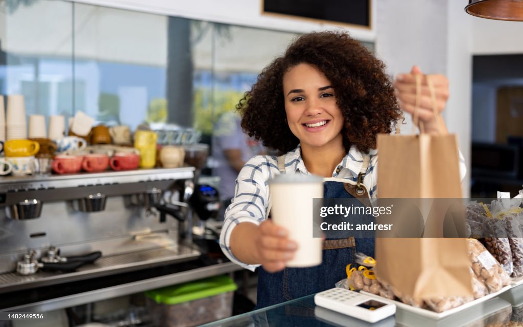 Happy waitress selling Take Out Food at a coffee shop